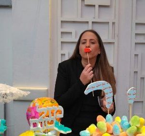 בר מתוקים עם אישה שמחזיקה מקל